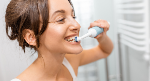 femme qui prends soin de ses dents pour éviter d'avoir une parodontite
