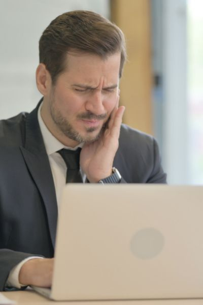 homme qui a mal aux dents au travail