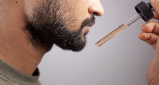 homme qui met du minoxidil pour faire pousser sa barbe