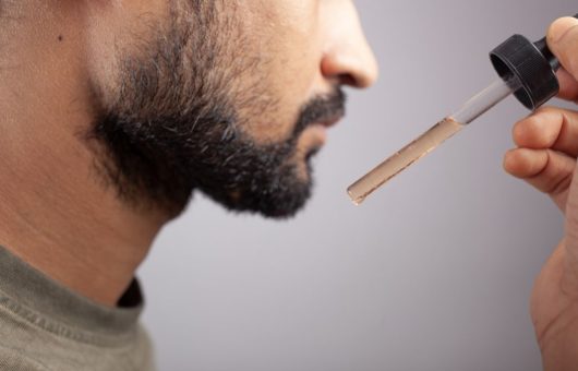 homme qui met du minoxidil pour faire pousser sa barbe