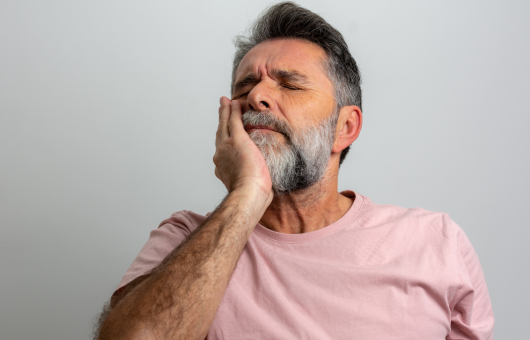 Homme qui a mal aux dents et a son implant
