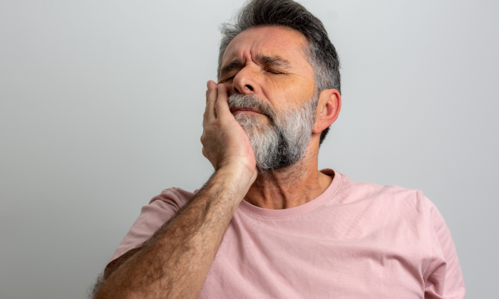 Homme qui a mal aux dents et a son implant
