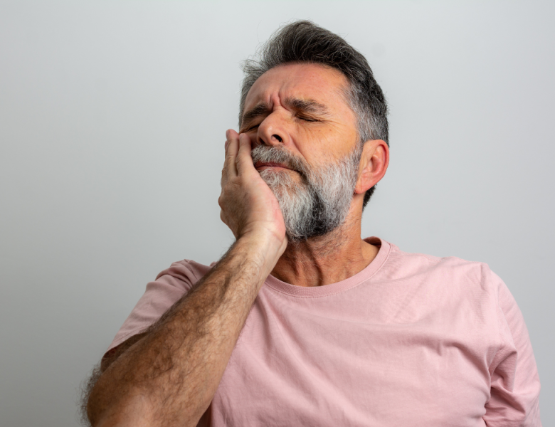 Homme qui a mal aux dents et a son implant