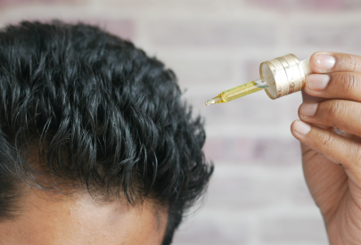 Homme qui utilise de l'huile de romarin cheveux