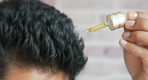 Homme qui utilise de l'huile de romarin cheveux