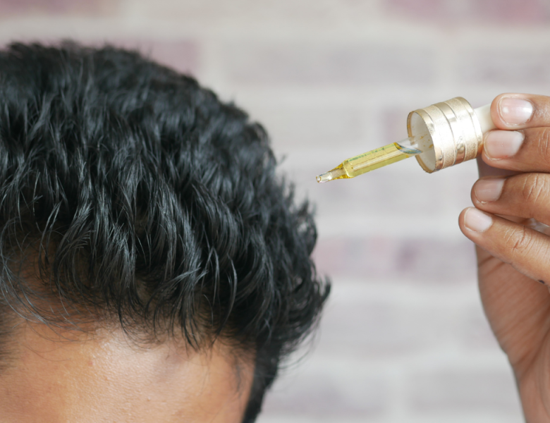 Homme qui utilise de l'huile de romarin cheveux